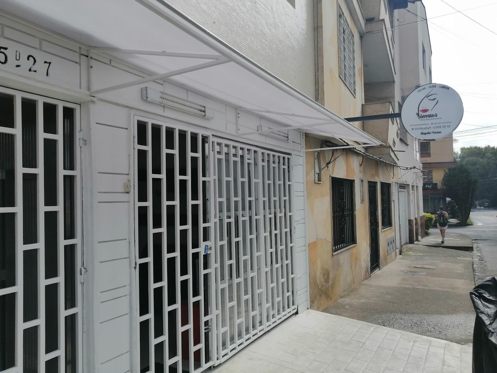 Fachada blanca del estudio con el letrero redondo de Lienzos